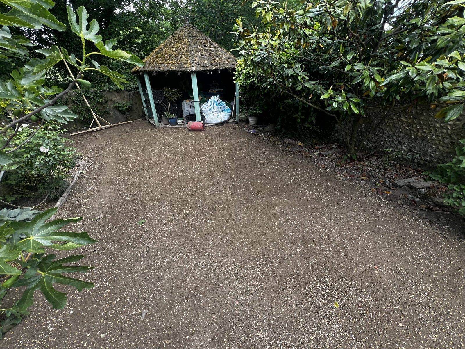 Hard, compacted bare ground beside the garden gazebo, with no usable lawn
