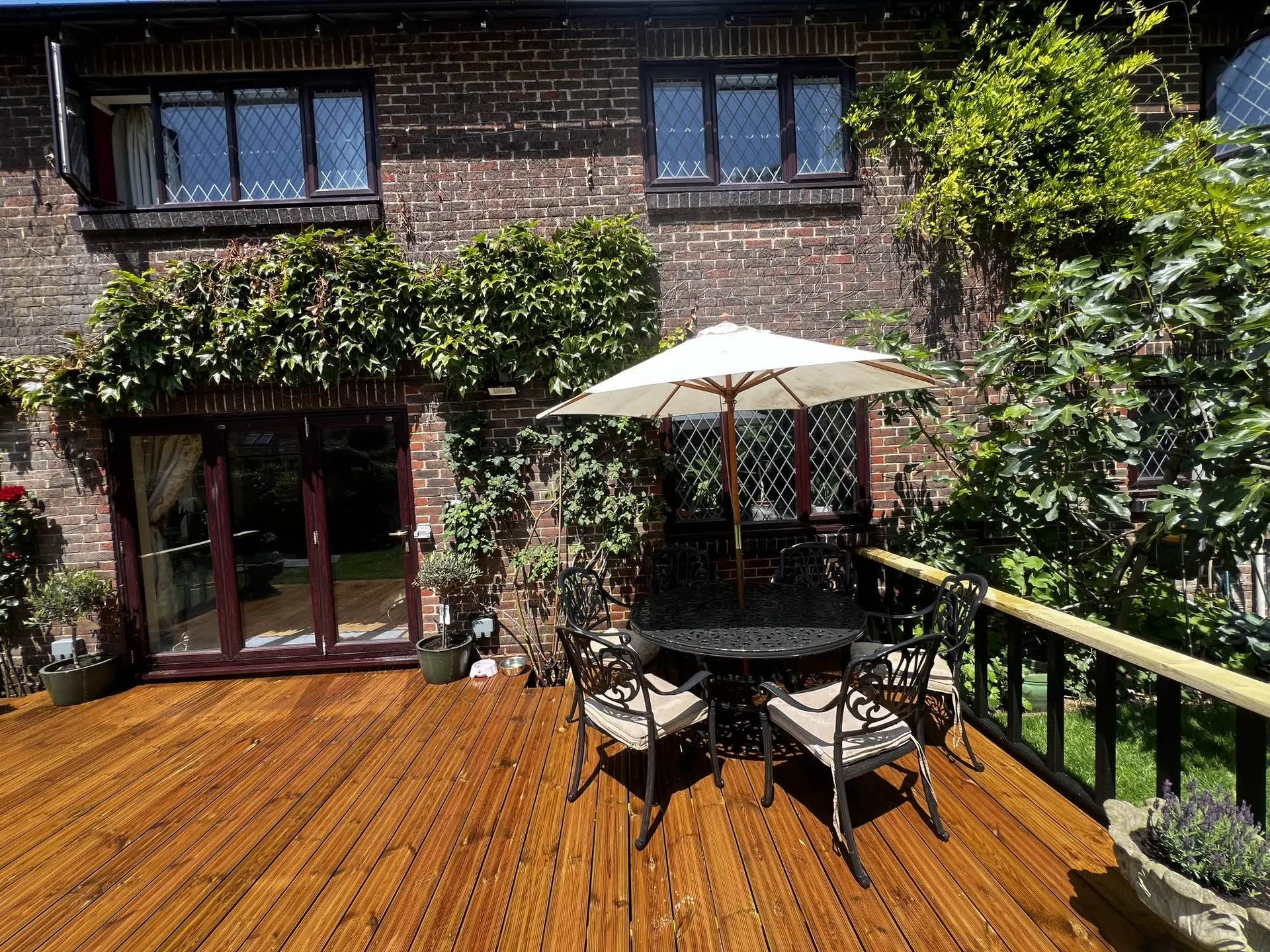 A closer view of the new timber deck and dining set against the house, before it was finished with a grey stain