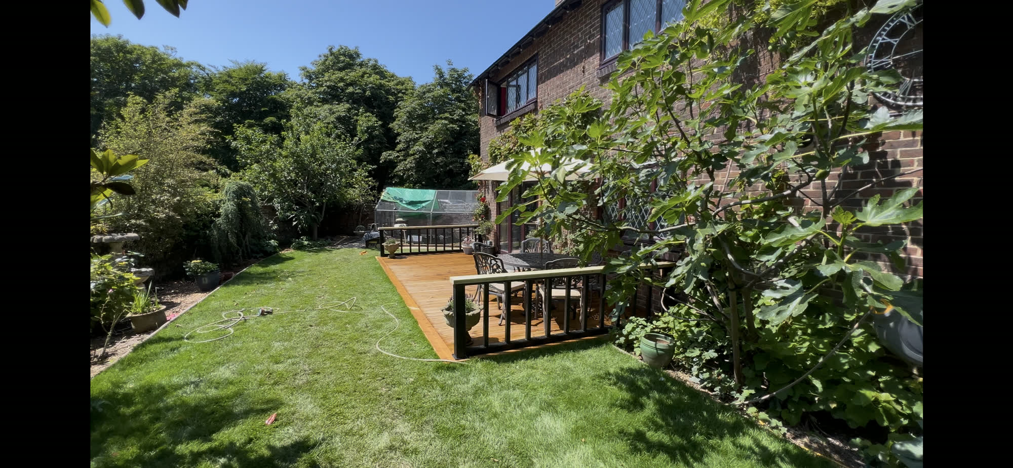 Wide view of the finished lawn and new deck spanning the garden, shortly before the grey stain finish was applied