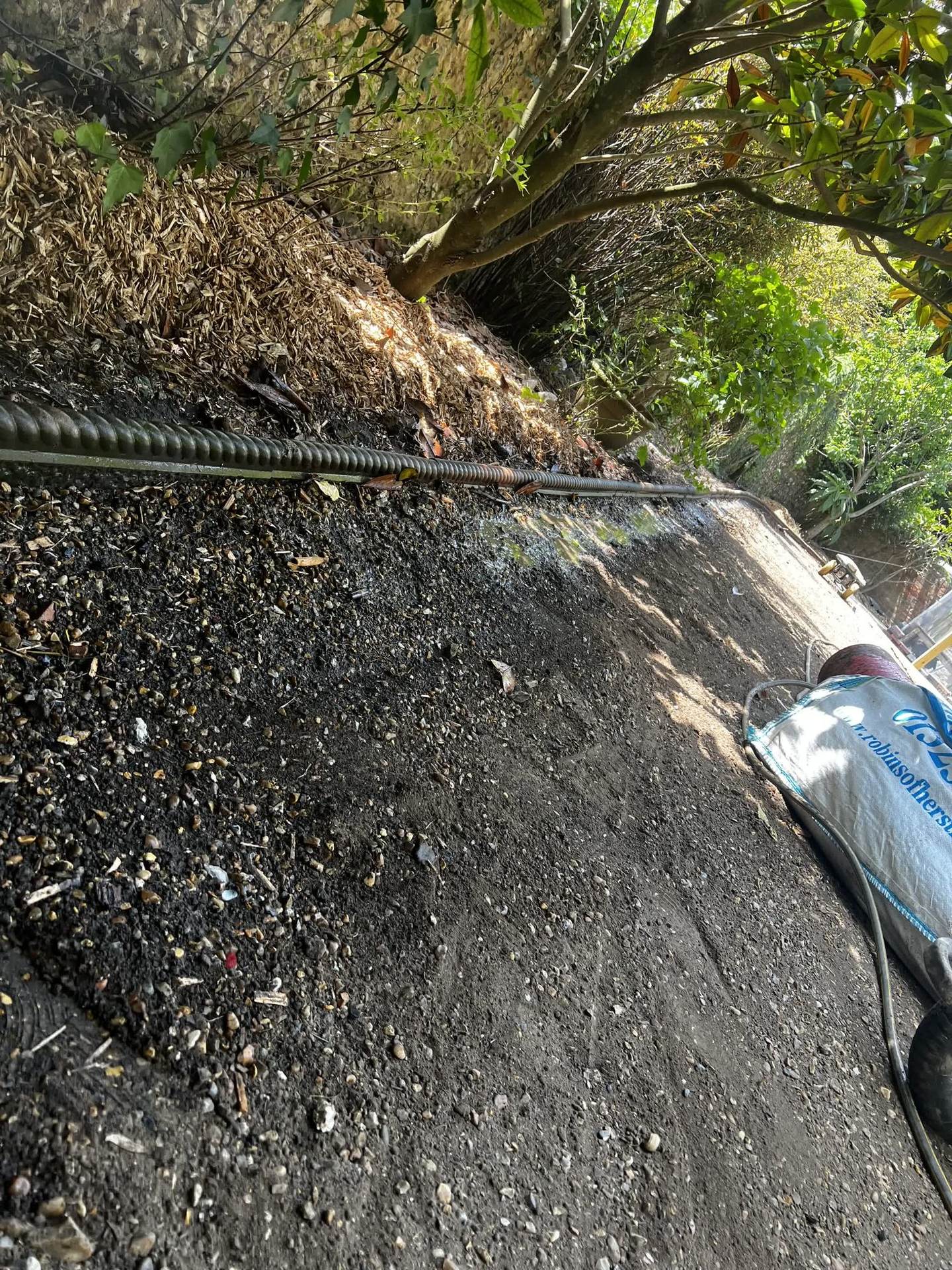 A land drain being laid in a trench as part of the new drainage system during ground preparation