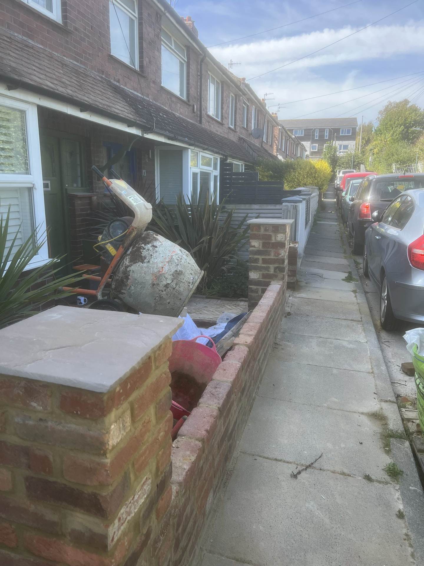 The rebuilt brick boundary wall with stone coping and pier, herringbone path leading to the front door